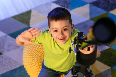 Little boy with telescope looking at the stars in the eveningの写真素材