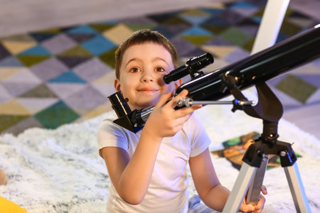 Little boy with telescope looking at the stars in the eveningの写真素材