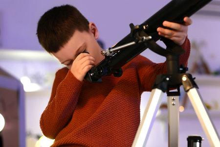Little boy with telescope looking at the stars in the eveningの写真素材
