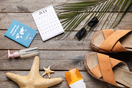 Calendar with beach accessories and immune passport on wooden backgroundの写真素材