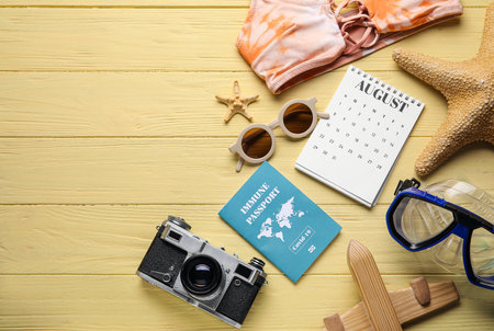 Calendar with beach accessories and immune passport on color wooden backgroundの写真素材