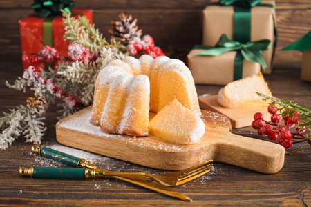Board with tasty Christmas cake, cutlery and decor on wooden tableの写真素材