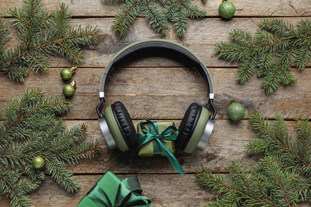 Composition with modern headphones, Christmas gifts, balls and fir branches on wooden backgroundの写真素材