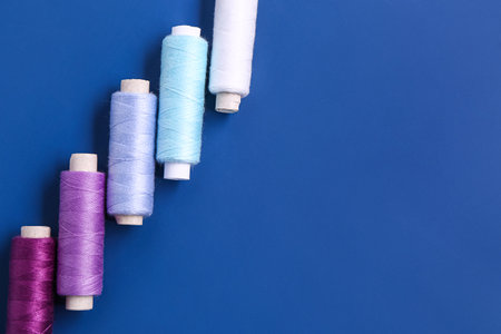 Set of thread spools on blue background