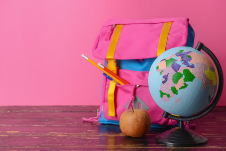 Globe, backpack and apple on table