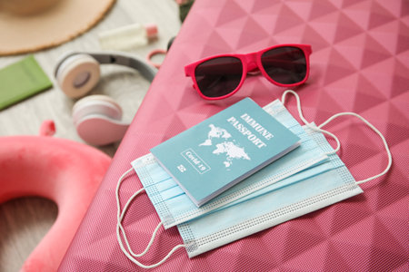 Suitcase with immune passport, medical masks and sunglasses, closeupの写真素材
