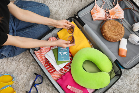 Woman packing suitcase at homeの写真素材