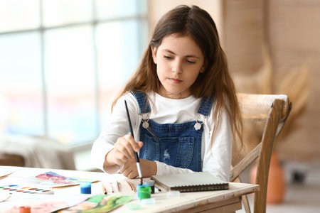 cute little girl painting at homeの写真素材