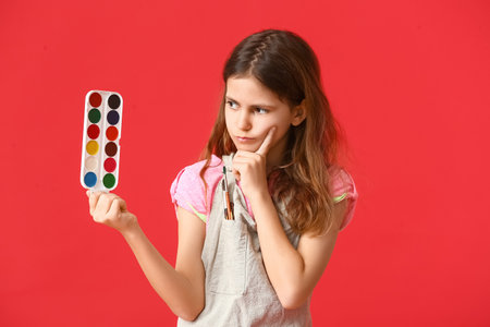 Thoughtful little painter on color backgroundの写真素材