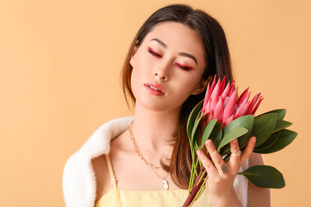 Beautiful young woman with protea flower on color backgroundの写真素材