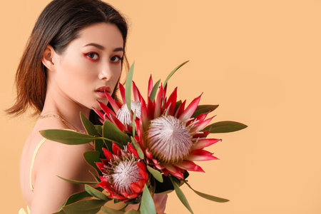 Beautiful young woman with protea flowers on color backgroundの写真素材