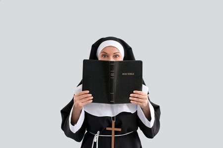 Shocked mature nun with Holy Bible on light backgroundの写真素材