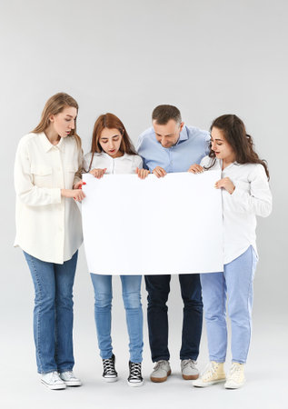 Group of people with blank poster on light backgroundの写真素材