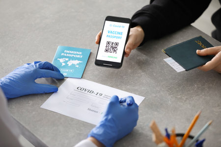 Doctor filling in international certificate of vaccination for touristの写真素材