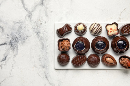Chocolate candies on white marble background