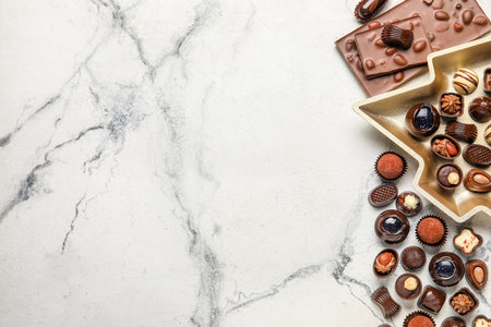 Candies and chocolate bar on white marble backgroundの写真素材