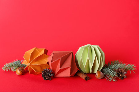 Paper Christmas balls with fir branches and cones on red backgroundの写真素材