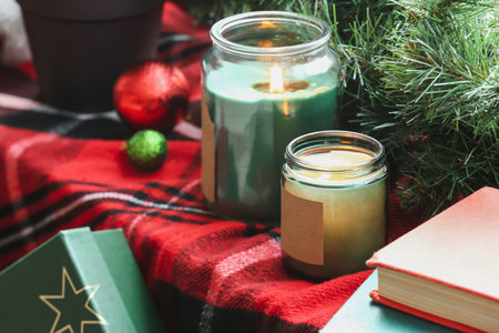 Burning candles and Christmas branches on plaid, closeupの写真素材