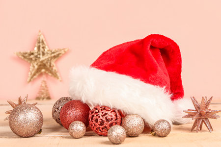 Composition with Santa hat and beautiful Christmas decor on table against pink backgroundの写真素材