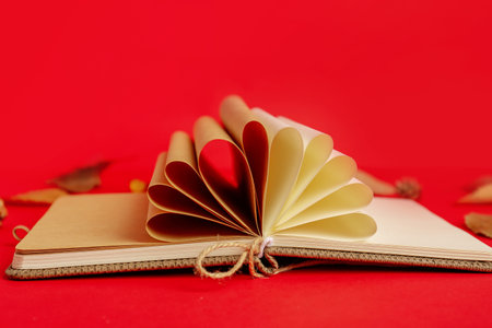 Notebook with rolled pages on red backgroundの写真素材