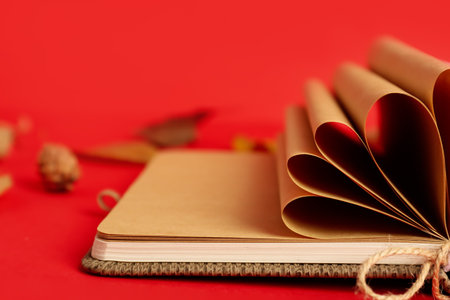 Notebook with rolled pages on red background, closeupの写真素材