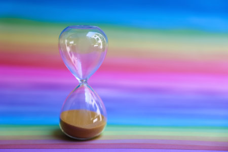 Modern hour glass on rainbow background