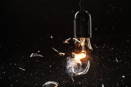 Breaking of vintage lamp on black background, closeupの写真素材