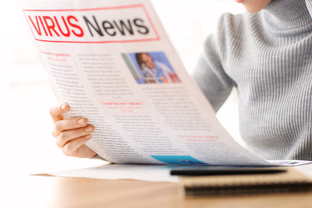 Young woman reading newspaper at home, closeupの写真素材