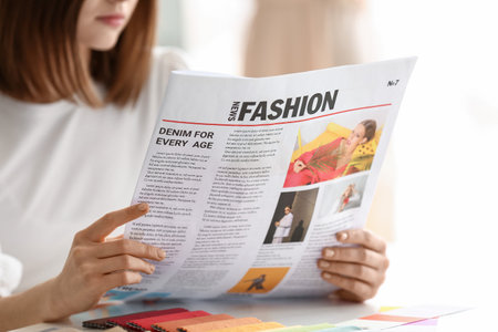 young woman reading newspaper at homeの写真素材
