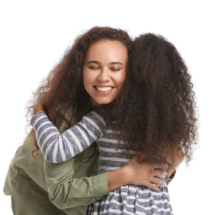African-American woman hugging her little daughter on white background