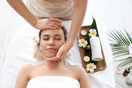 Beautiful young African-American woman getting massage in spa salonの写真素材