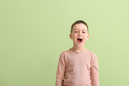 Little boy training pronounce letters on color backgroundの写真素材