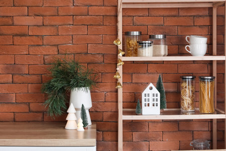 Shelving unit with candle holder, Christmas trees and jars of food in kitchen
