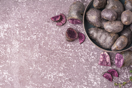 Bowl of raw purple potatoes on grunge backgroundの写真素材