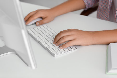 Young man typing on computer keyboard while studying online at home, closeupの写真素材