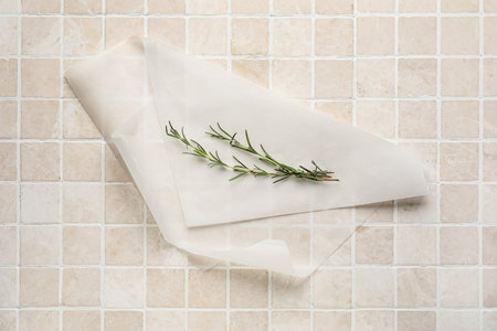 Baking paper with rosemary on beige tile backgroundの写真素材