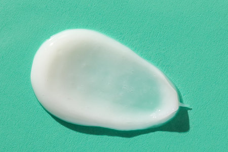 Sample of moisturizing cream on green backgroundの写真素材