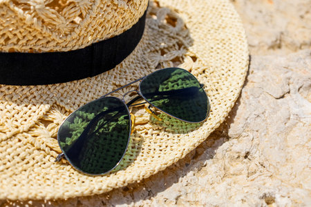 Beautiful hat with sunglasses on natural rock, closeup