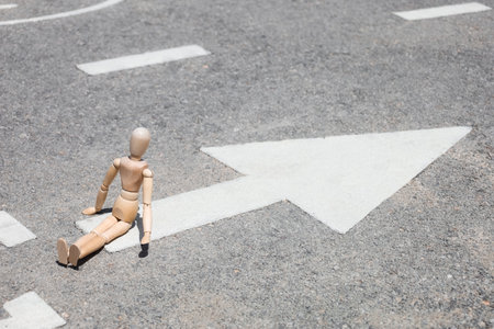 Wooden mannequin on road with bicycle signs in city, closeupの写真素材