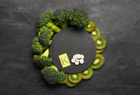 Composition with healthy products, letter K and pills on black backgroundの写真素材