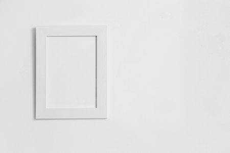 Blank photo frame on white wall