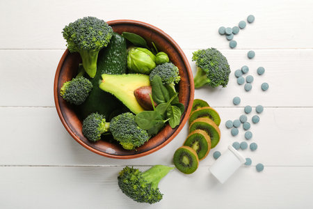 Bowl with healthy products and bottle of pills on white wooden backgroundの写真素材