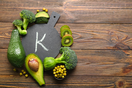 Board with letter K and healthy products on wooden backgroundの写真素材