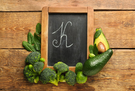 Chalkboard with letter K and healthy products on wooden backgroundの写真素材