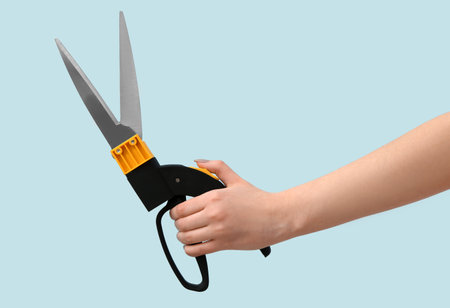 Female gardener with pruner on blue backgroundの写真素材