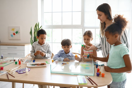 Little children with teacher during master class in Ebru painting at workshop