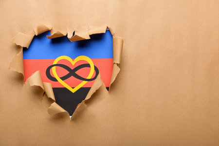 Polyamory flag visible through torn beige paperの写真素材