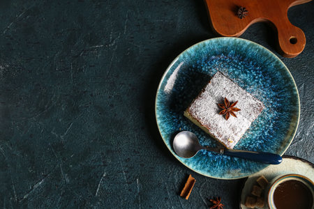 Blue plate with piece of cheese pie and anise on black backgroundの写真素材