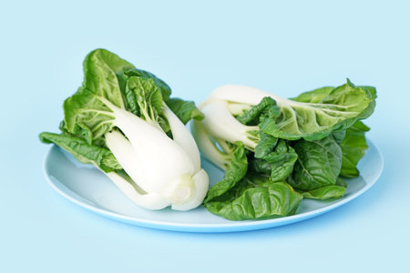 Plate of fresh pak choi cabbage on color backgroundの写真素材