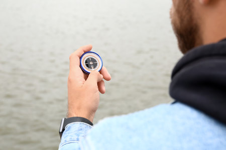 Man with compass near river, closeupの写真素材